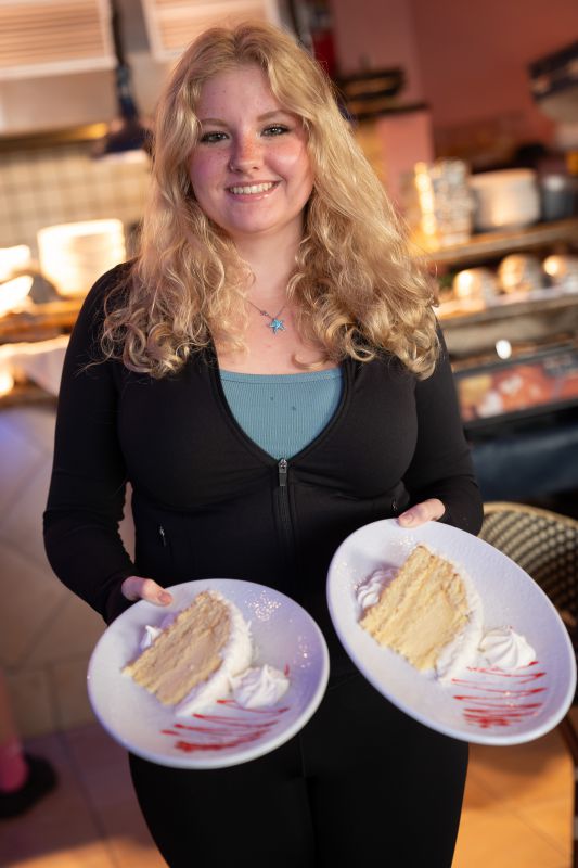 A server presenting a slice of key lime cake