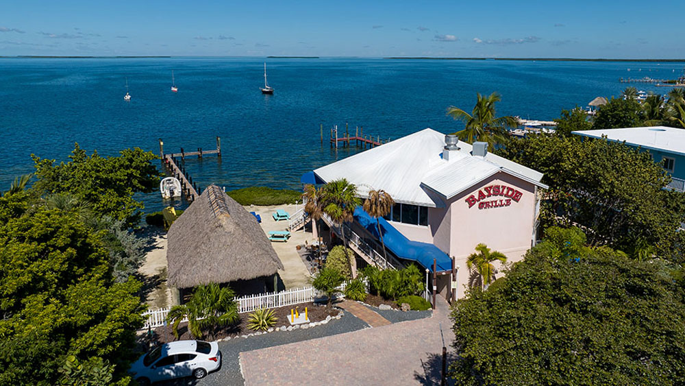 Daytime aerial of the Bayside Grille building beside the bay
